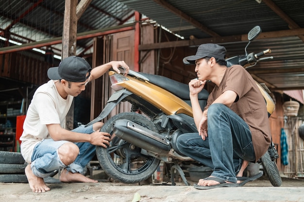 mechanic helping a customer to fix scooter motorbike