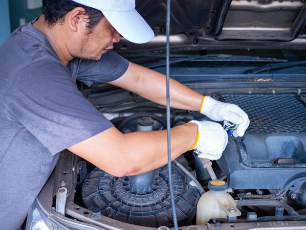 Mechanic holding a block wrench handle while fixing a car.