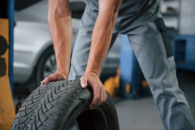 Mechanic holds a tire at the repair garage