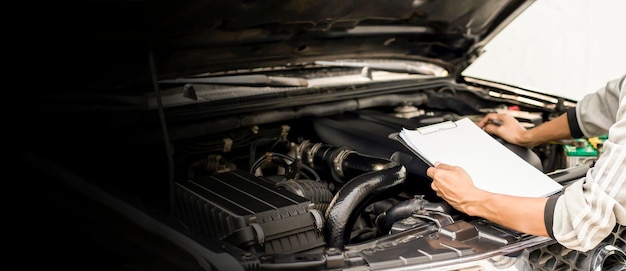 The mechanic is checking the cars engine to make it ready for use