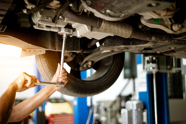 Mechanic is turning the nut to fix the car in the garage,Repair service.