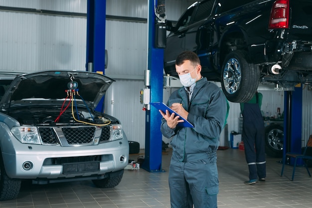 Mechanic maintaining car record on clipboard at the repair shop.