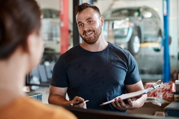 Photo mechanic man and customer talk with car report and clipboard for maintenance and repair check conversation garage and motor inspection with paperwork and auto consultation for technician job