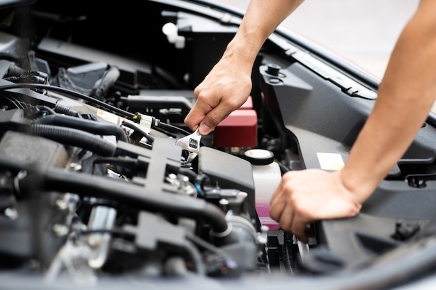 Mechanic man working and repair car engine in car service centre.