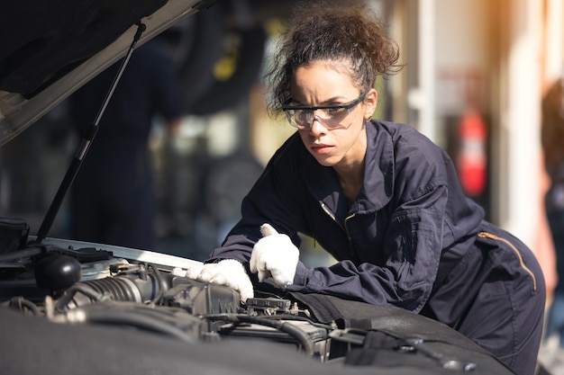 Mechanic repairing the motor or electric parts of a car in a garage
