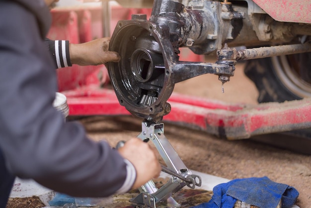 Mechanic repairing tractor axle close to axle