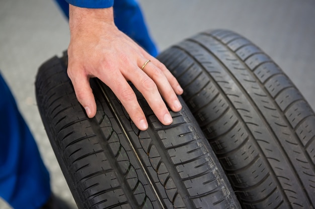 Mechanic rolling a tire wheel