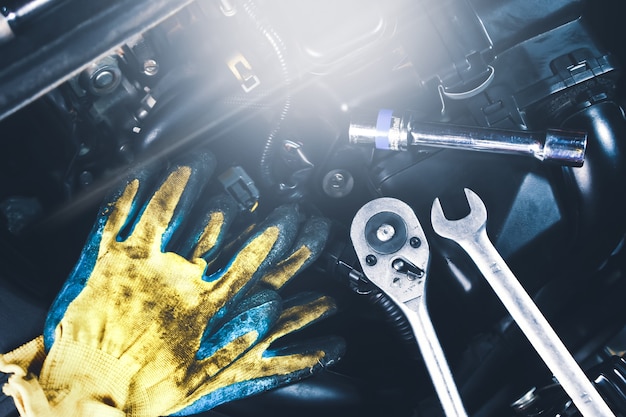 Mechanic tools place on the engine car such as gloves,socket spanner,combination wrench