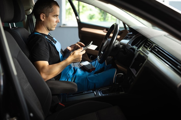 Mechanic using tablet pc at the repair garage service using digital tablet for car diagnostic