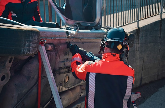 Mechanic with helmet cutting a car in an attempt to repair it