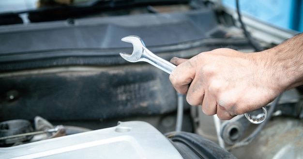 Mechanic with wrench in hand. Car maintenance