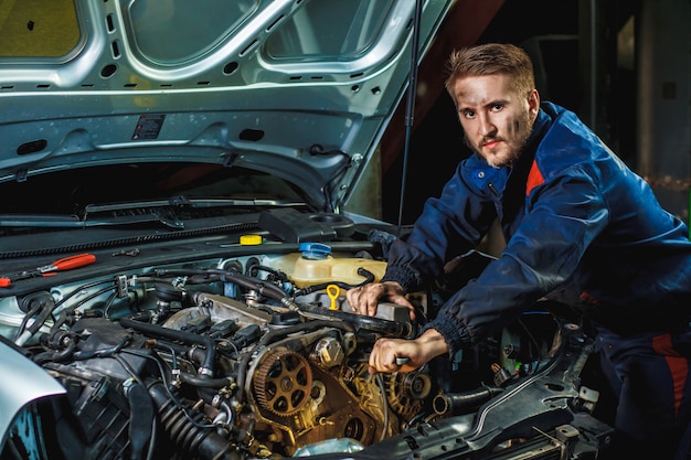 Mechanic working in car motor. Auto repair, Service center. 