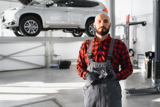 Mechanic working and holding wrench of service order for maintaining car at the repair shop