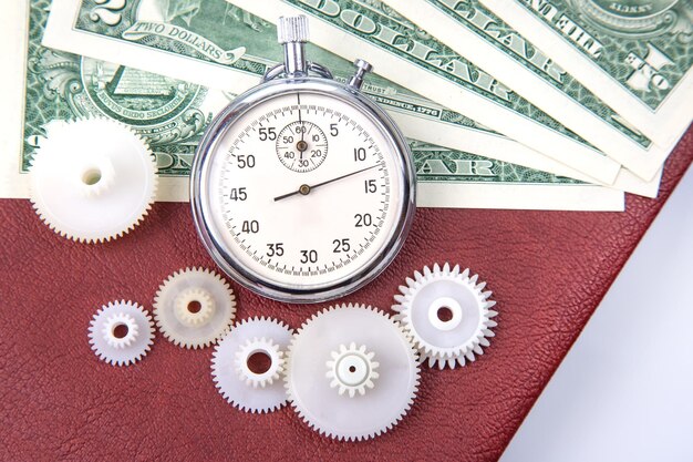 Photo mechanical stopwatch on the background of dollars part time accuracy for business business and finance time