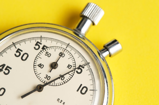 Photo mechanical stopwatch yellow background closeup