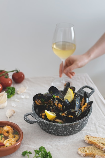 Medditeranean lunch, fresh cooked mussels with tomato, parsley, lemon, fresh bread and white wine