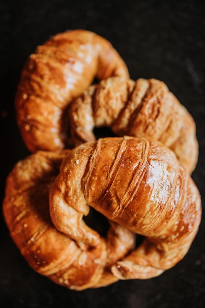 medialunas, argentinian sweet croissant over a black backdrop. copy space