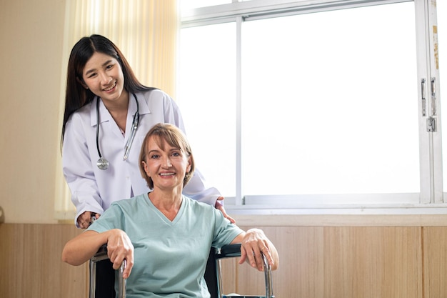 Medical adult for enjoy and take care health in hospital.Doctor holding wheel chair for support patient in clinic room.