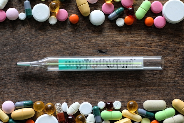 Medical background of various colorful medications on a textured wooden