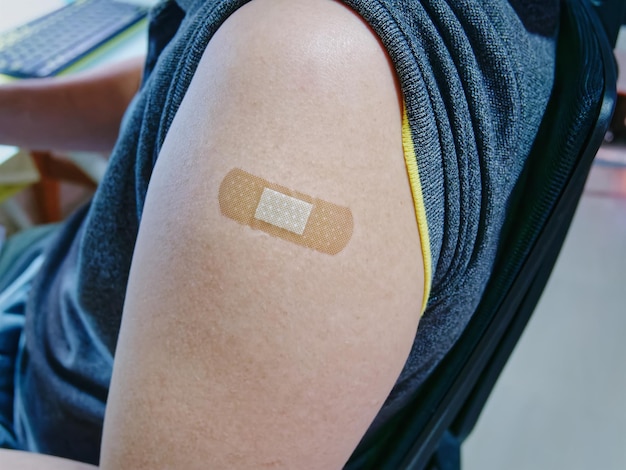 Medical Bandage Plaster on Mans Arm After Getting Vaccinated