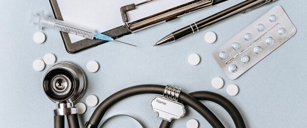 Photo medical concept flat lay with stethoscope, pills, notepad, pen on the doctor desktop