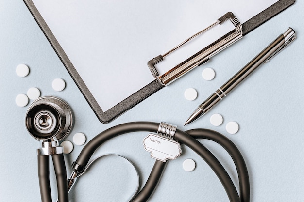 Photo medical concept flat lay with stethoscope, pills, notepad, pen on the doctor desktop