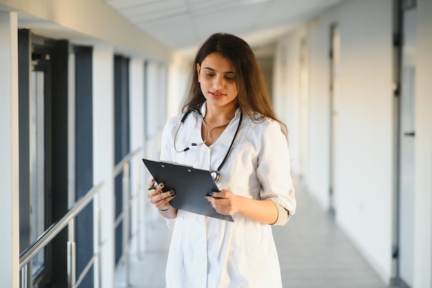 Medical concept of Indian beautiful female doctor in white coat with stethoscope, waist up. Medical student.