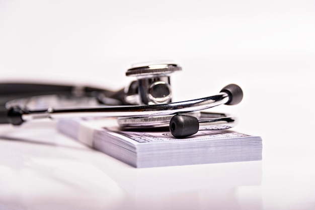 Medical concept stethoscope over the dollar bills isolated on white background