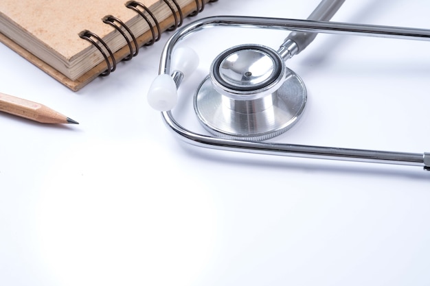 Medical concept : stethoscope, note book and pencil with white background