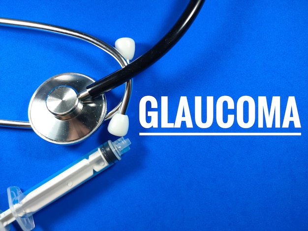 Medical conceptText GLAUCOMA with Syringe and stethoscope on blue background