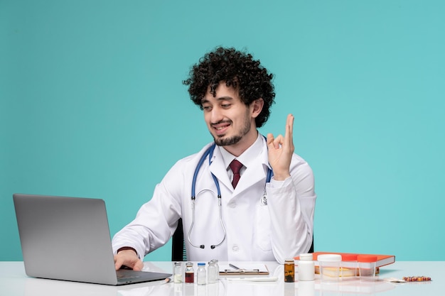 Medical cute handsome doctor working on computer remotely in lab coat confident