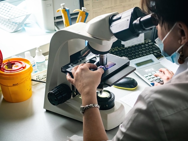 Medical Development Laboratory Caucasian Female Scientist Looking Under Microscope