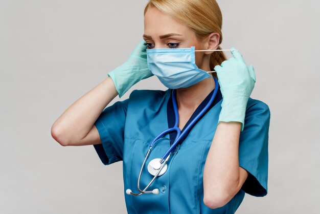 Medical doctor nurse woman with stethoscope wearing protective mask and rubber or latex gloves