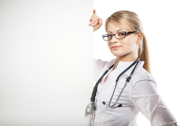 Medical doctor woman smile with stethoscope hold blank card board showing hand open palm concept advertisement product empty copy space over white background