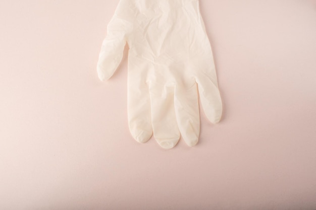 Photo medical glove on pink background elastic disposable gloves latex sterile protective glove close up females doctor hygiene health care beauty salon covid19 high quality photo