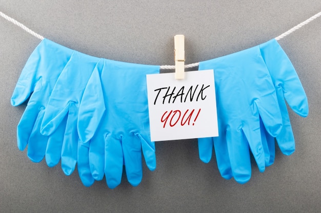 Photo medical gloves with the inscription thank you gratitude to doctors during covid concept