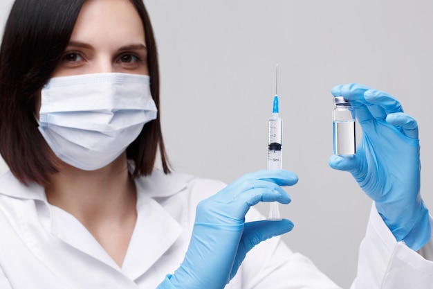 Medical injection,diseases,health care,science,diabetes.Doctor or nurse in hospital holding a syringe with liquid vaccines preparing to do an injection.Medical equipment. People in white uniform,robe