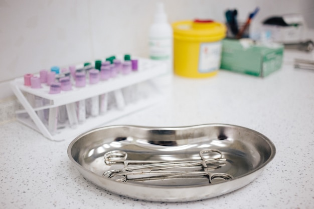 Medical instruments in the tray, disposable gloves on the table. health