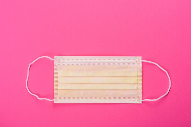 Medical mask on a pink table