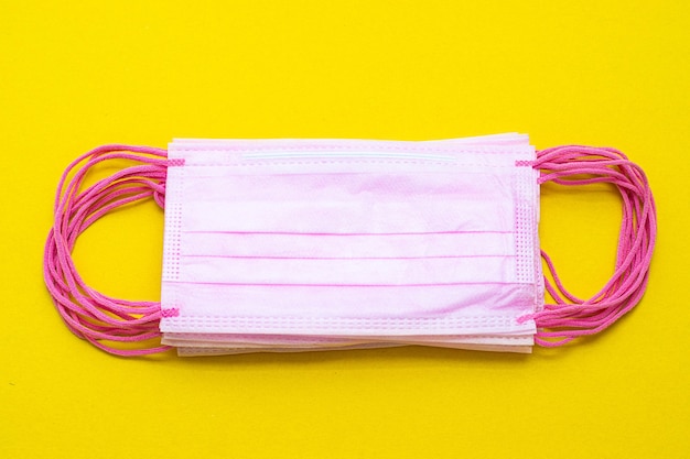 Medical masks isolated on yellow