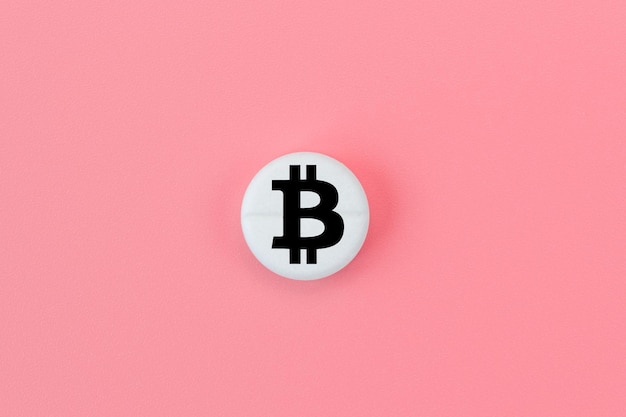 Medical pill with a bitcoin sign on a pink background Bitcoin technology concept in medicine