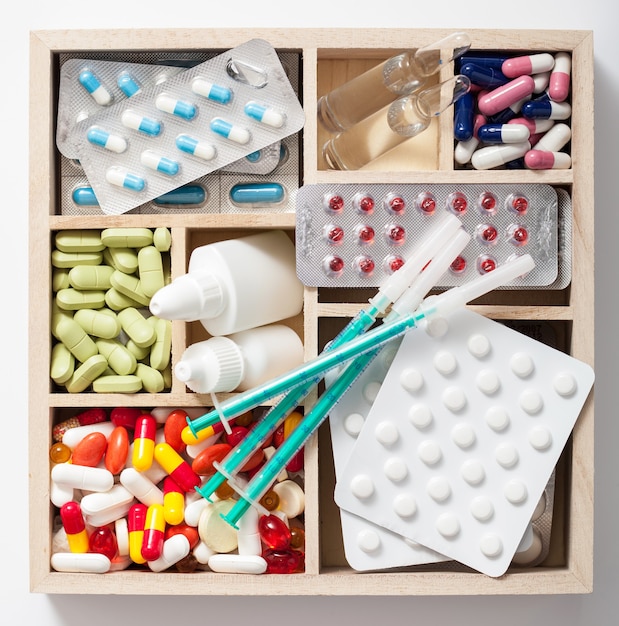 Medical pills and ampules in wooden box