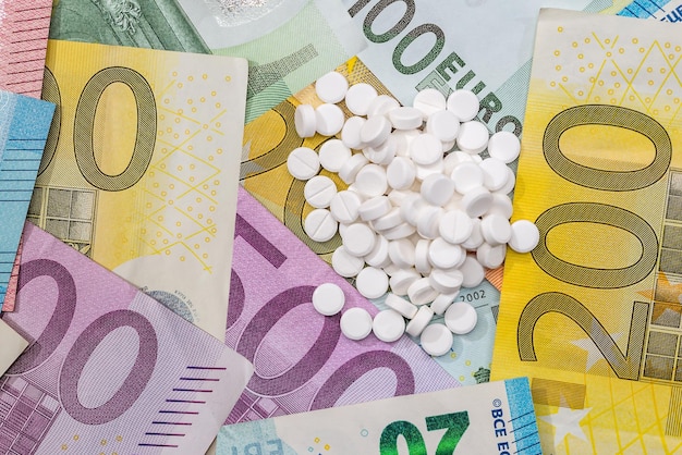 Medical pills tablets in blister with Euro currency banknotes concept of high medical expenses