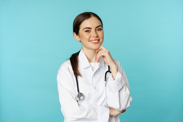 Medical staff and doctors concept young smiling female doctor healthcare worker in white coat and st...