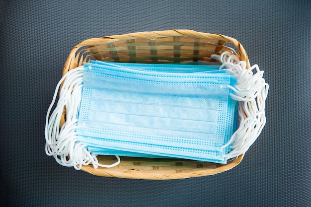 Medical sterile masks are in a basket in a pile