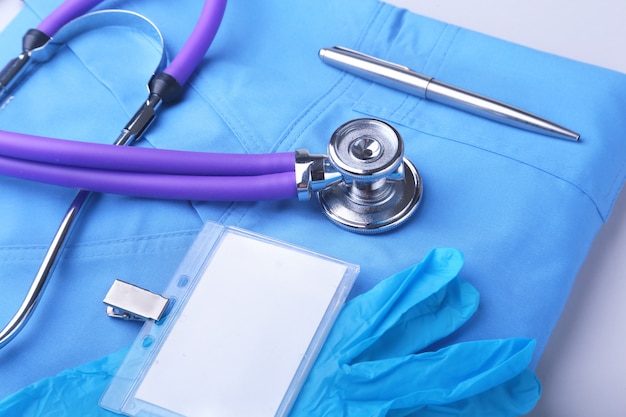 Medical stethoscope lying on a blue doctor's form and notepad close-up. the therapist's work space.