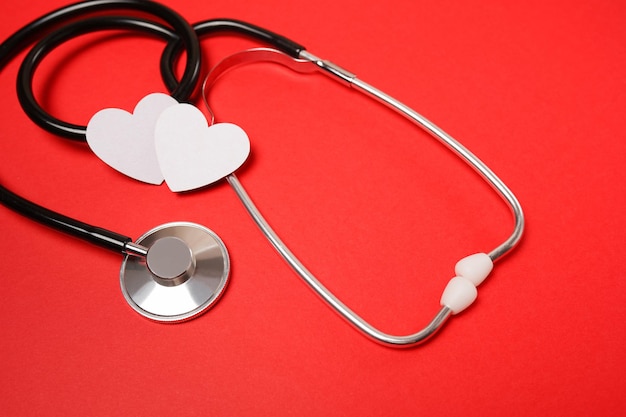 Medical stethoscope and red hearts on red background using for healthcare, medical, treatment, education and Valentine concept