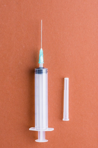 Medical syringe on orange background