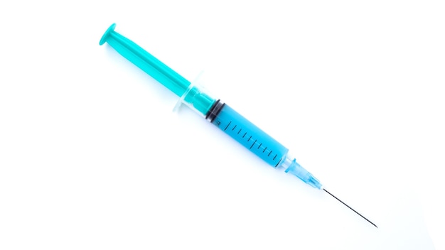 Medical syringe with coronavirus vaccine on white background