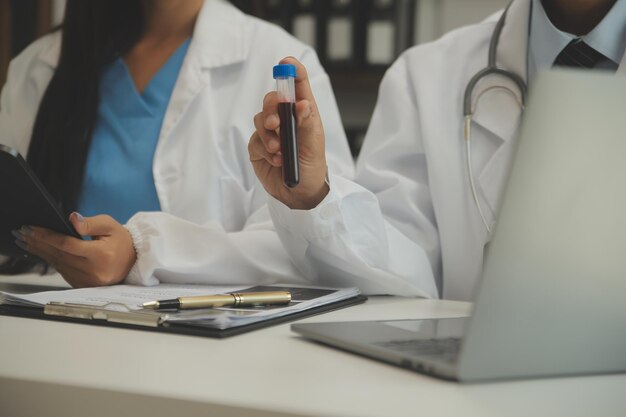 Medical team having a meeting with doctors in white lab coats and surgical scrubs seated at a table discussing a patients recordssuccess medical health care Medicine doctor's working concept